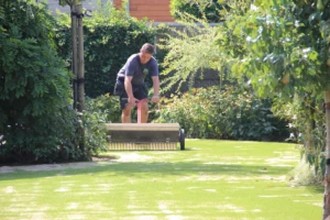 Inzanden kunstgras in de tuin door een werkman van het Kunstgrascentrum